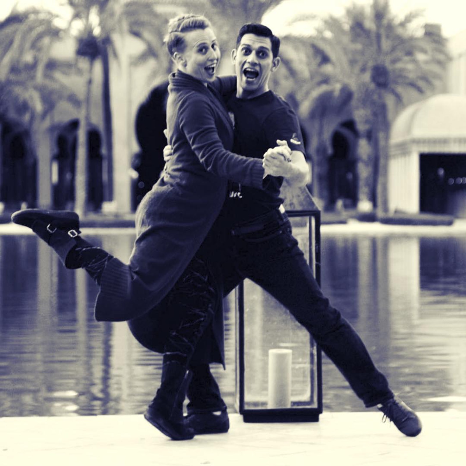 Ivan and Sara laughing in a playful pose by a pool
