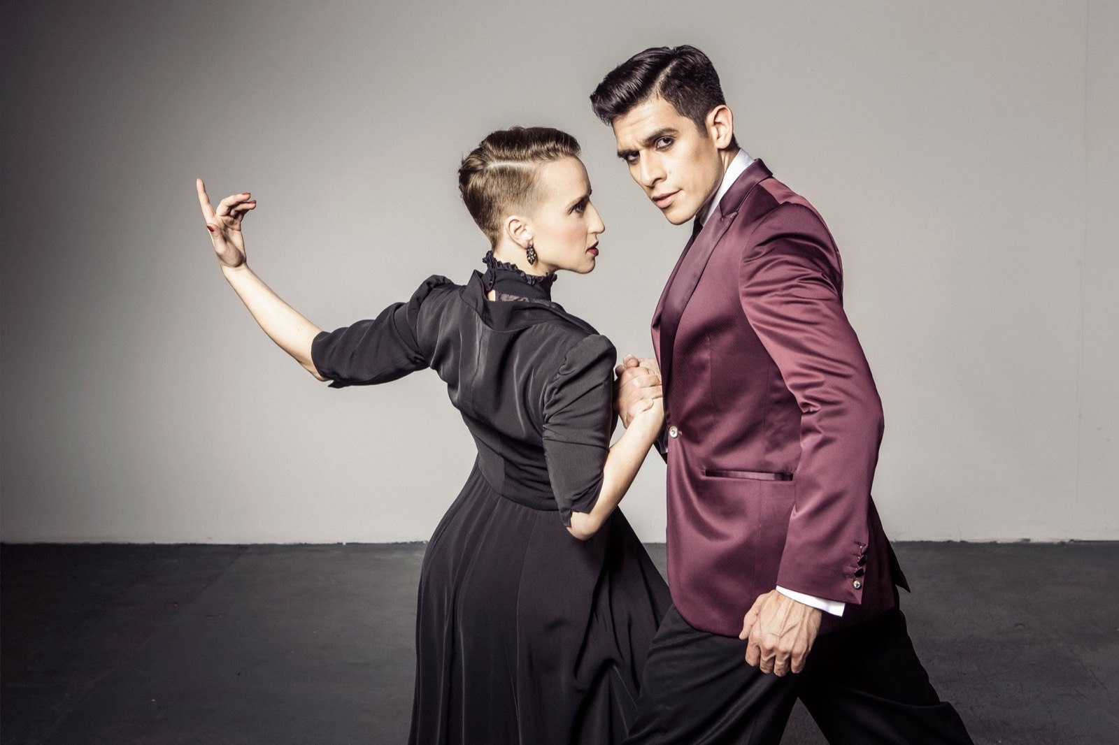 Sara in black and Ivan in a burgundy jacket, studio pose